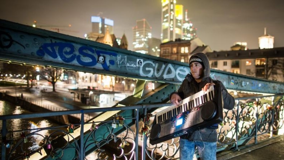 Șomer român cântând pe străzile din Frankfurt pentru a-și întreține familia